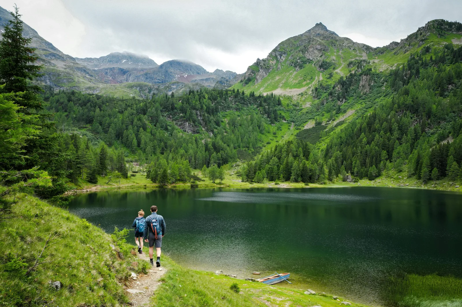 Travellers walking near a lake in the mountains